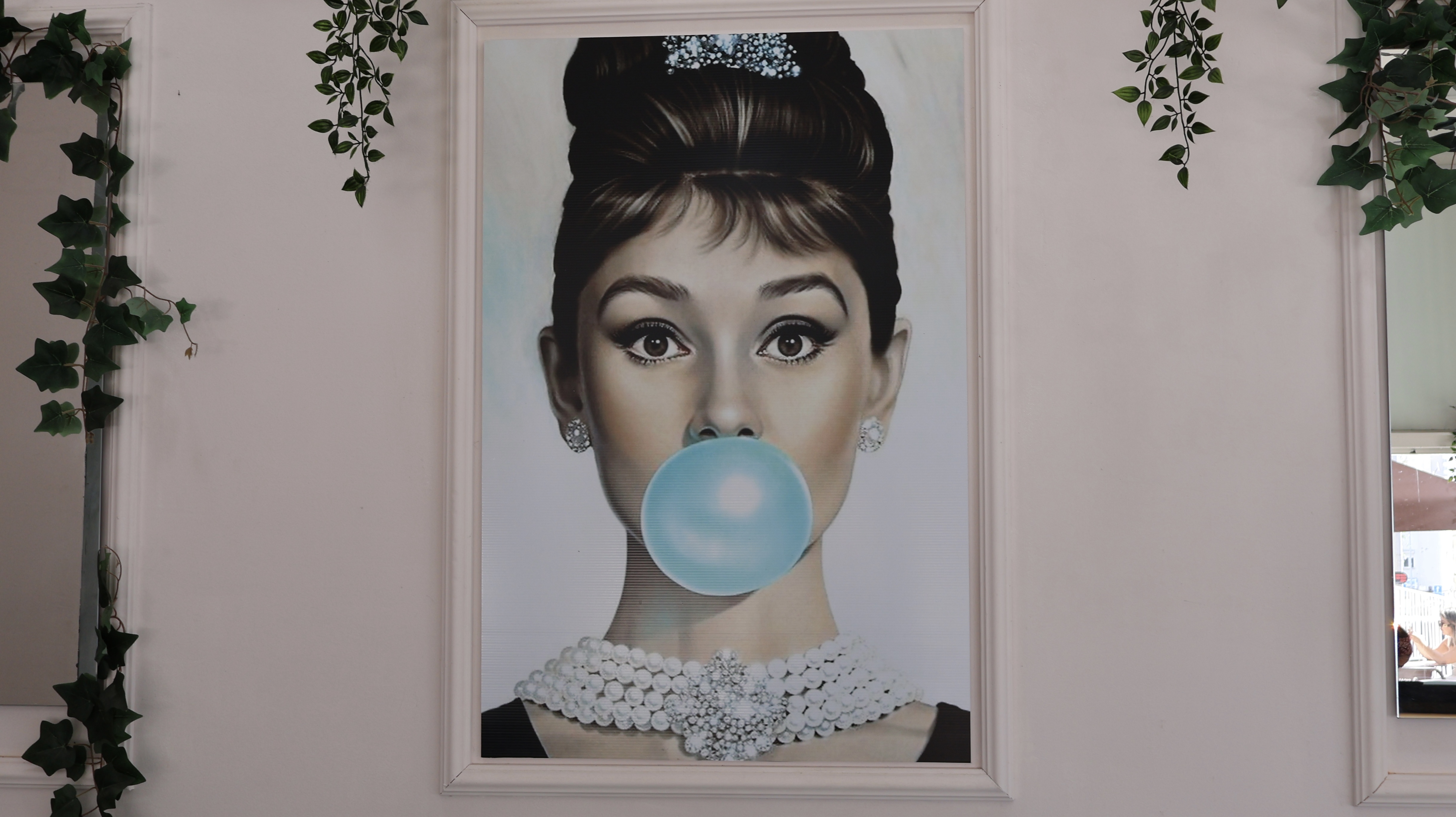 Audrey Hepburn blowing a bubble gum